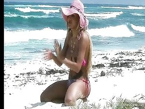 Shemale pornstar Karla Carrillo on the beach in a pink hat